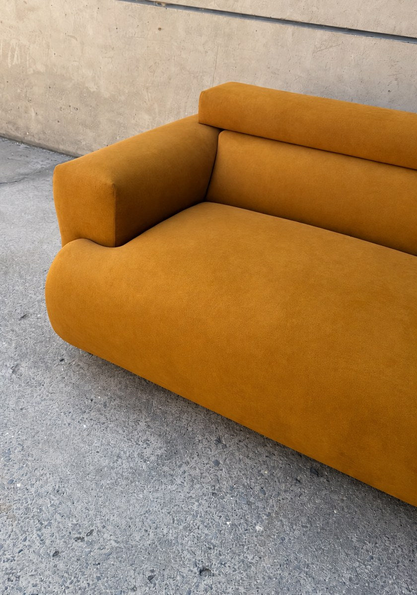 Harvey sofa in Electra Amber against a concrete wall