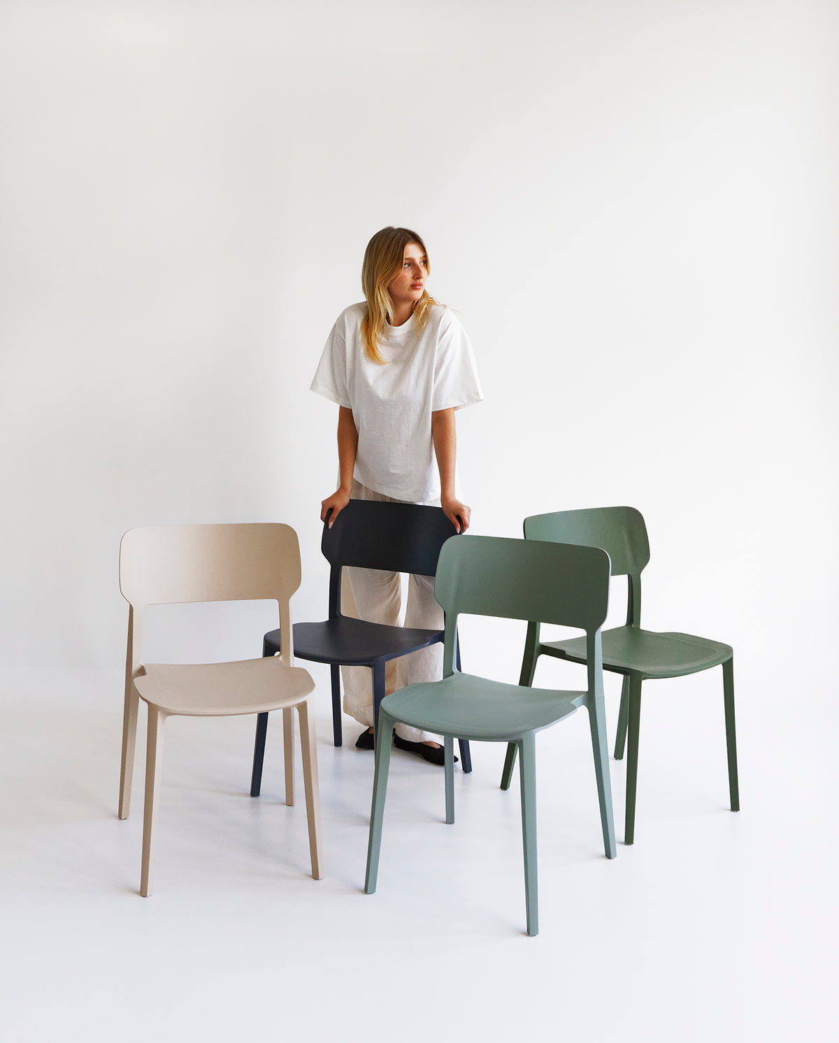 Front view of the Beige Alex Chair, a plastic indoor outdoor dining chair with a curved back and clean silhouette.