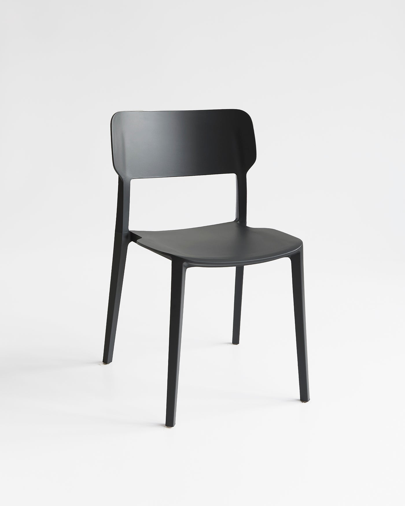 Front view of the Black Alex Chair, a durable plastic chair with a curved backrest and clean silhouette for indoor and outdoor use.