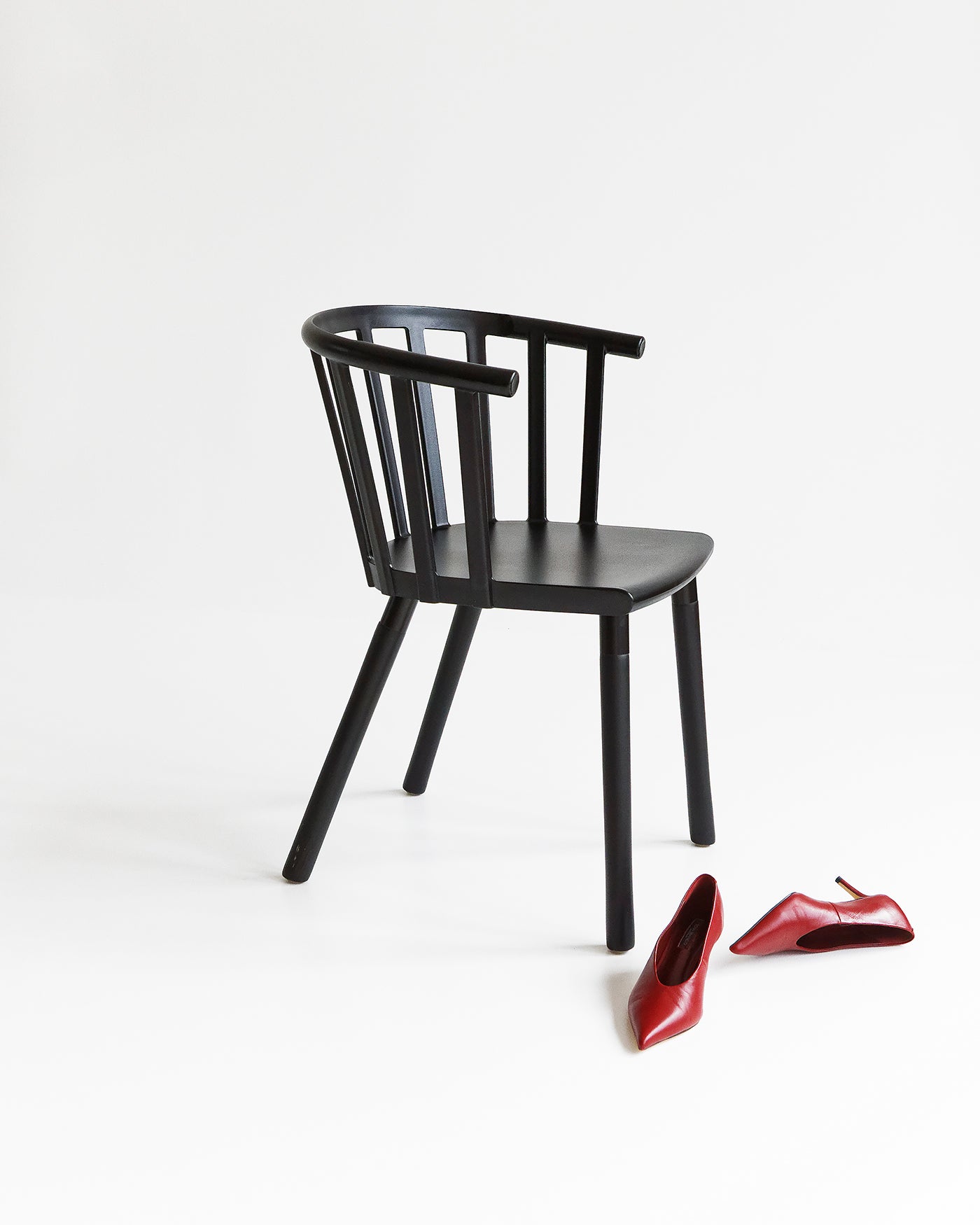Vicky black dining chair shown from an angle, highlighting curved back and slender legs