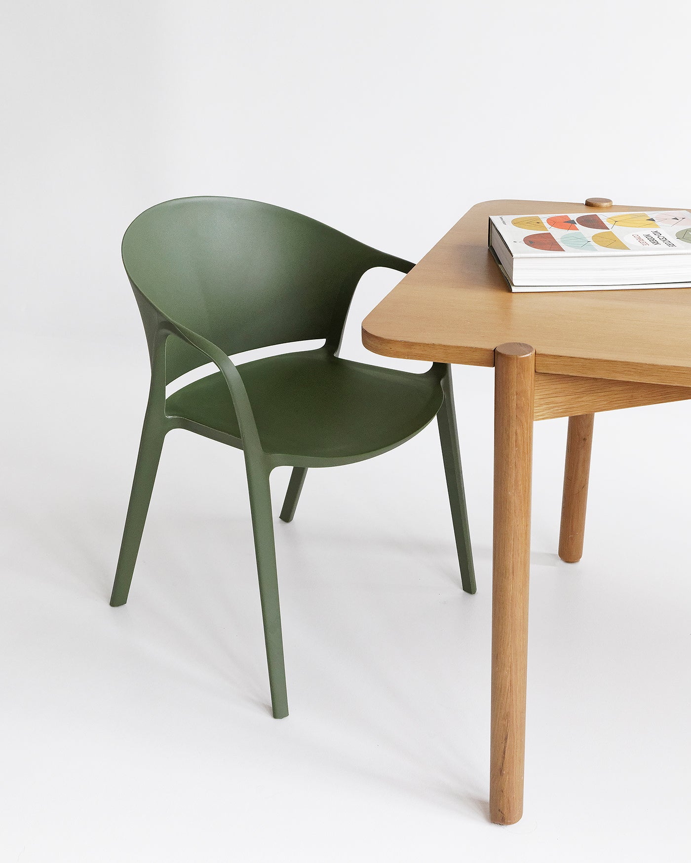 Indoor dining scene featuring the Olive Carla Armchair paired with a minimalist table and neutral interior.