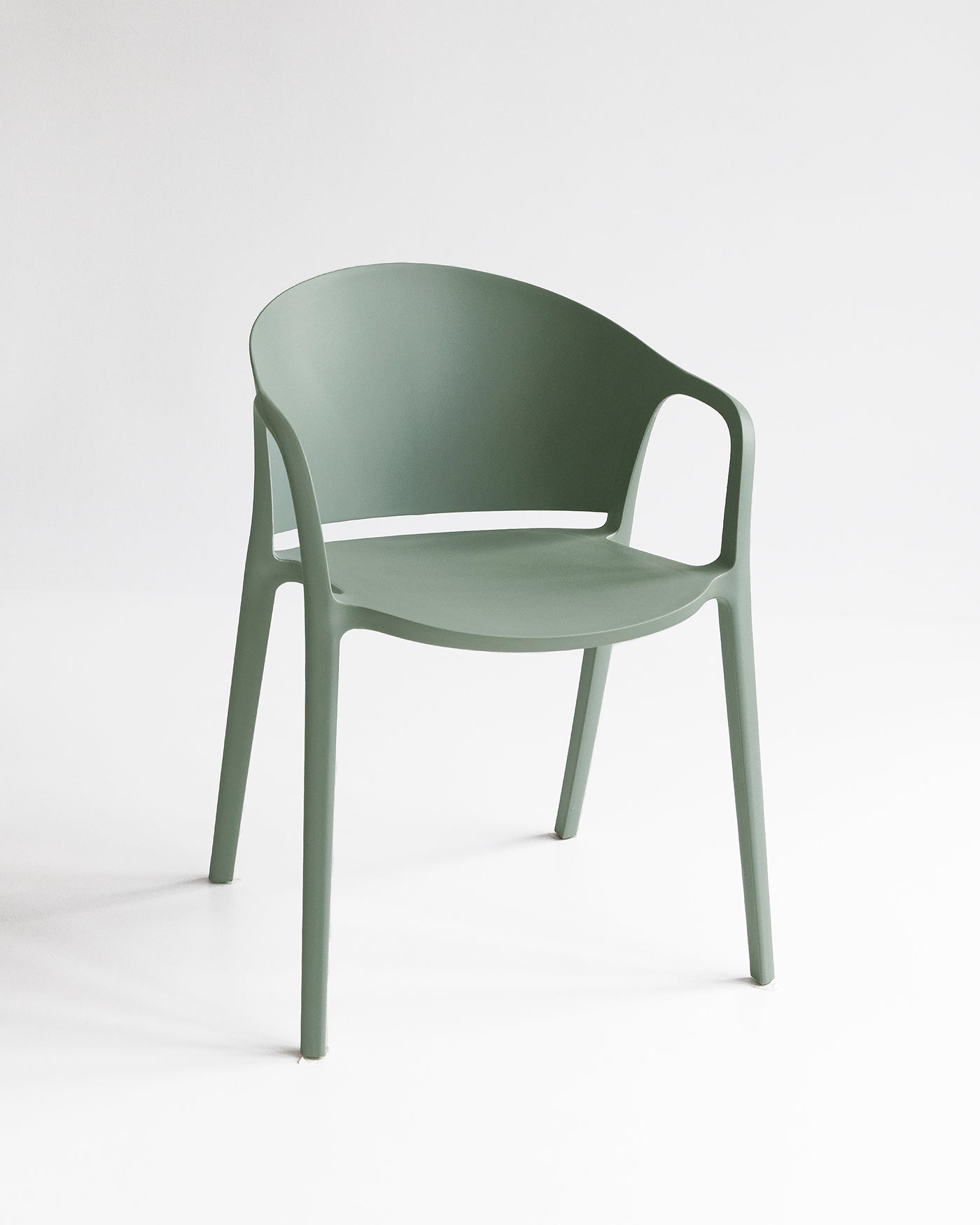 Front angle of the Carla Chair in Sage, a stackable plastic dining chair for indoor outdoor spaces.
