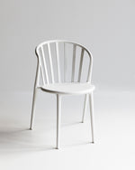 White Cleo dining chair photographed front-on, showing slim silhouette and curved backrest for indoor and outdoor use