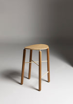 Oak Greta stool shown front-on in a studio setting with light timber seat and slim metal legs