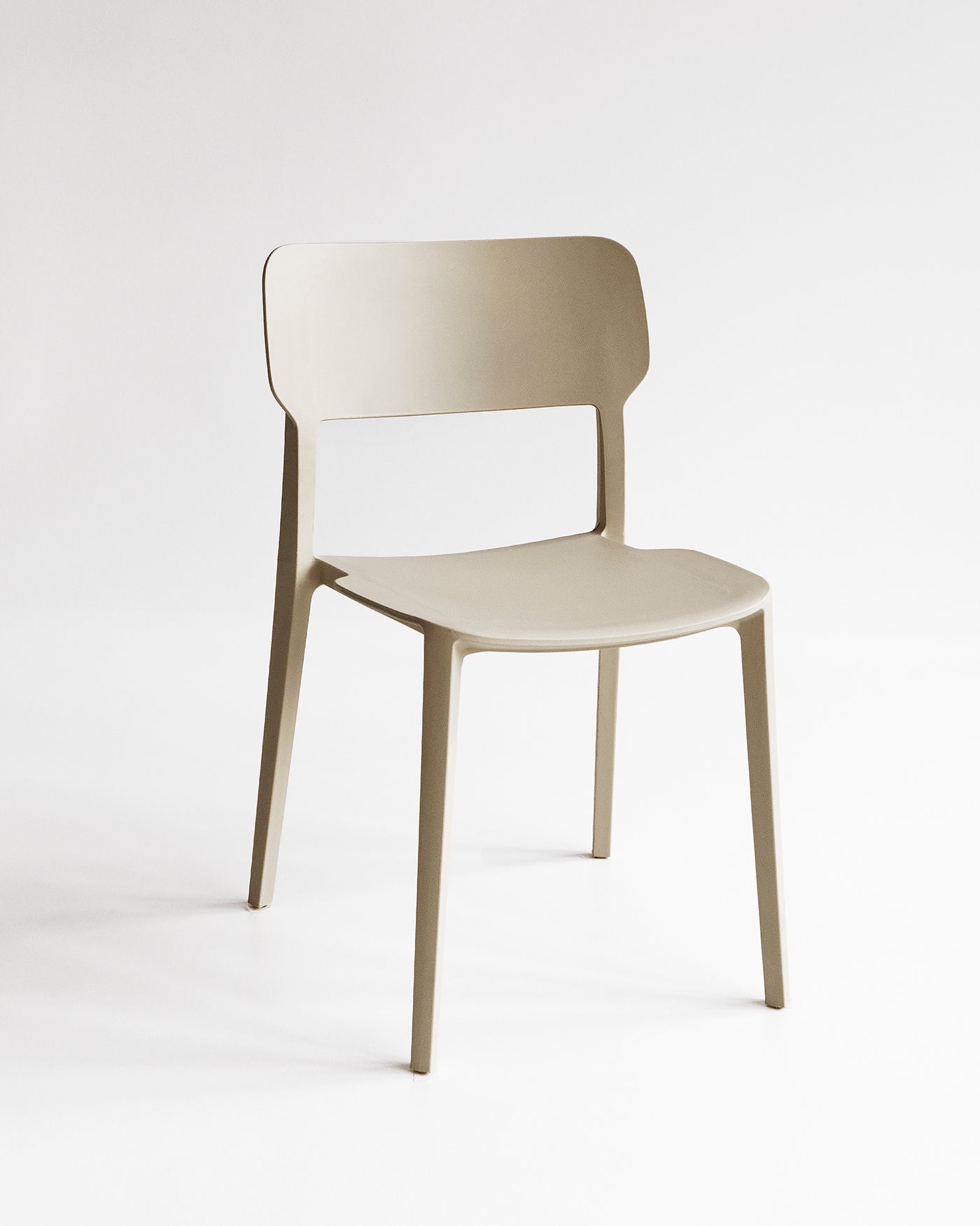 Front view of the Beige Alex Chair, a plastic indoor outdoor dining chair with a curved back and clean silhouette.