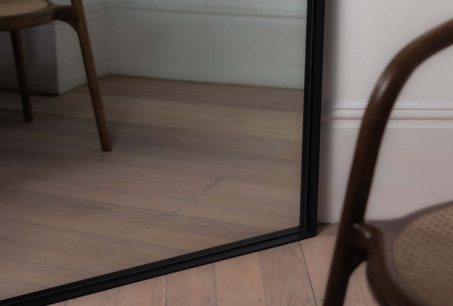 Close-up of the black Archie Arch Mirror frame showing recessed metal edge