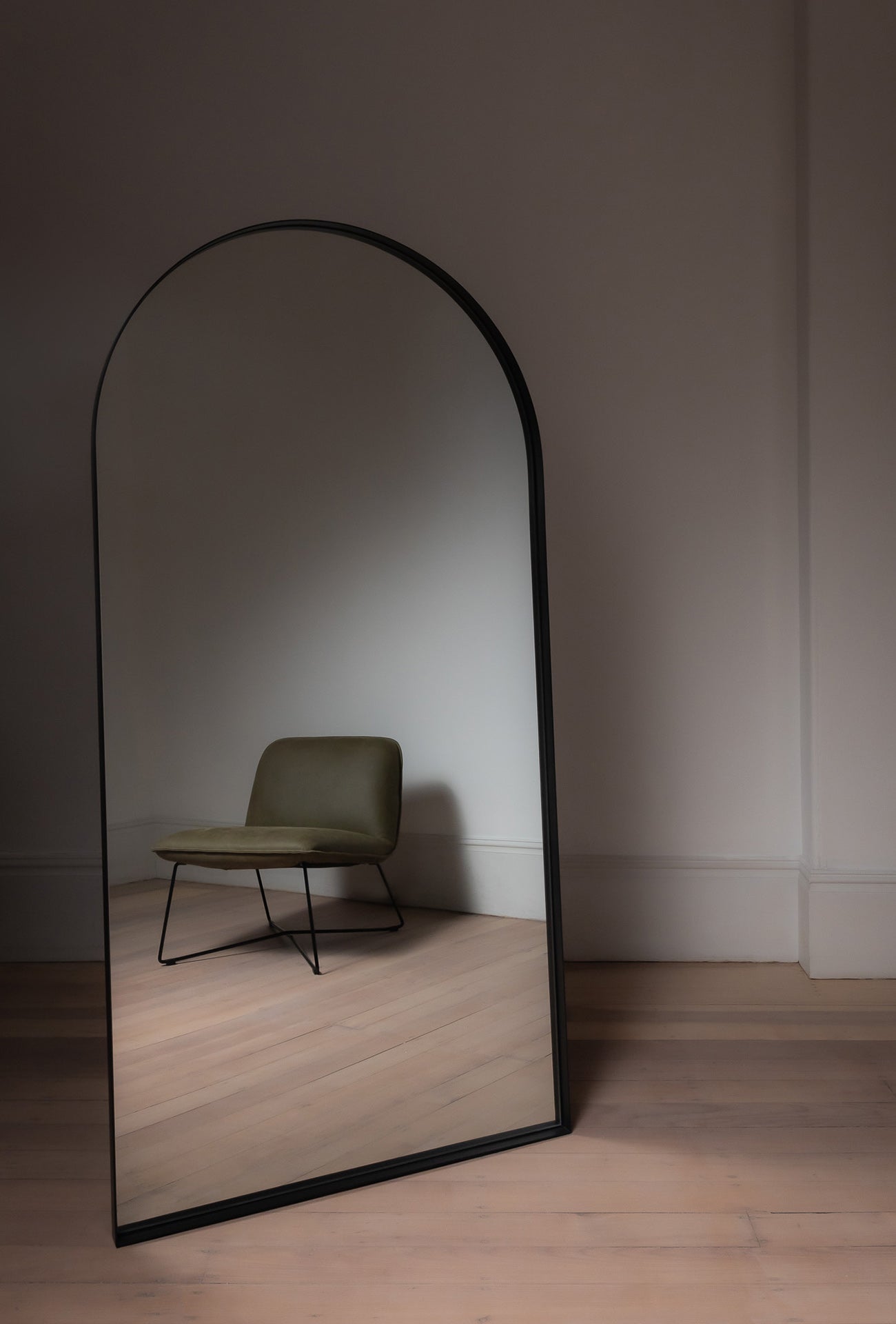 Black Archie Arch Mirror in a minimal room, large full length mirror reflecting neutral décor
