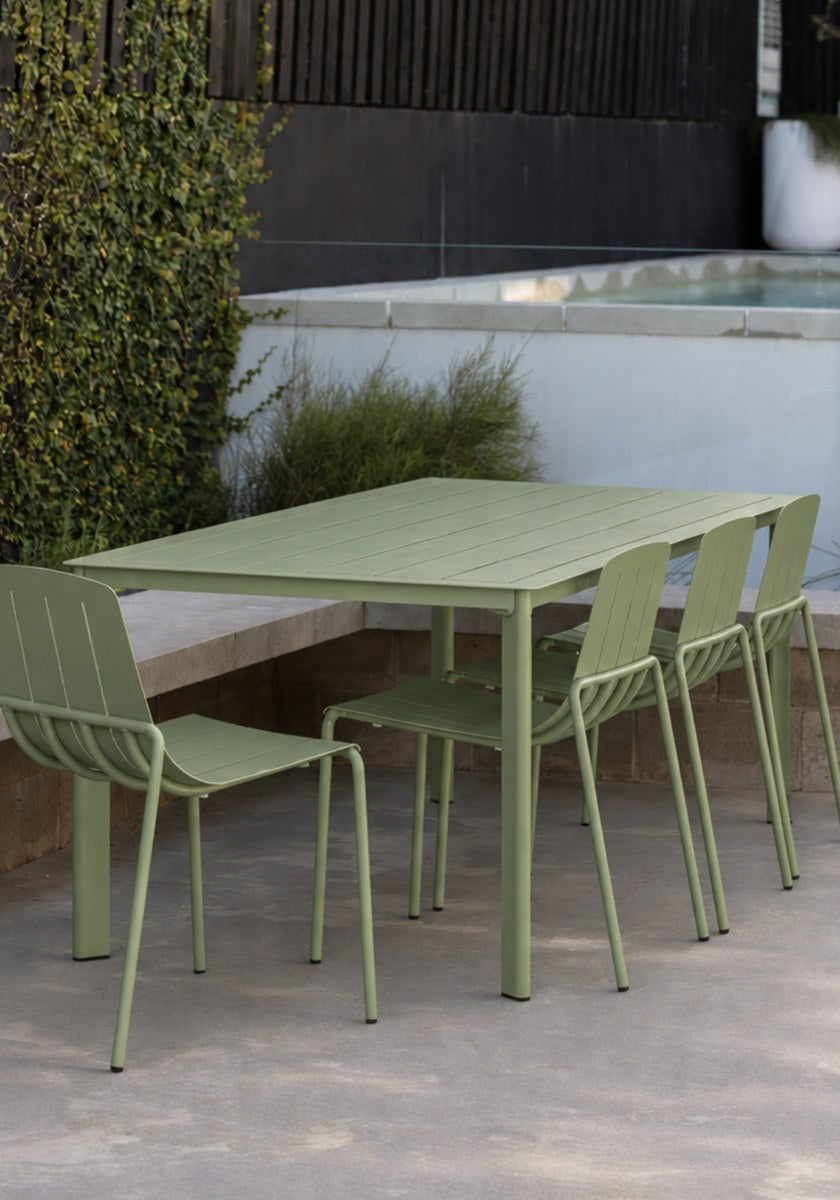 Green outdoor dining set by a pool