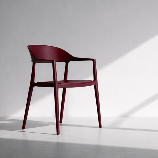 Red chair in a minimalistic room with sunlight streaming through a window.