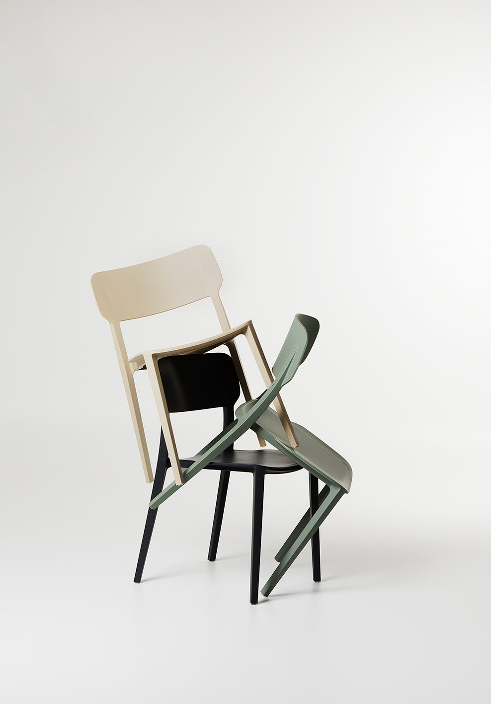 Artistic stack of Beige Alex Chairs in a sculptural arrangement, showcasing their lightweight design and playful versatility in a styled studio setting.