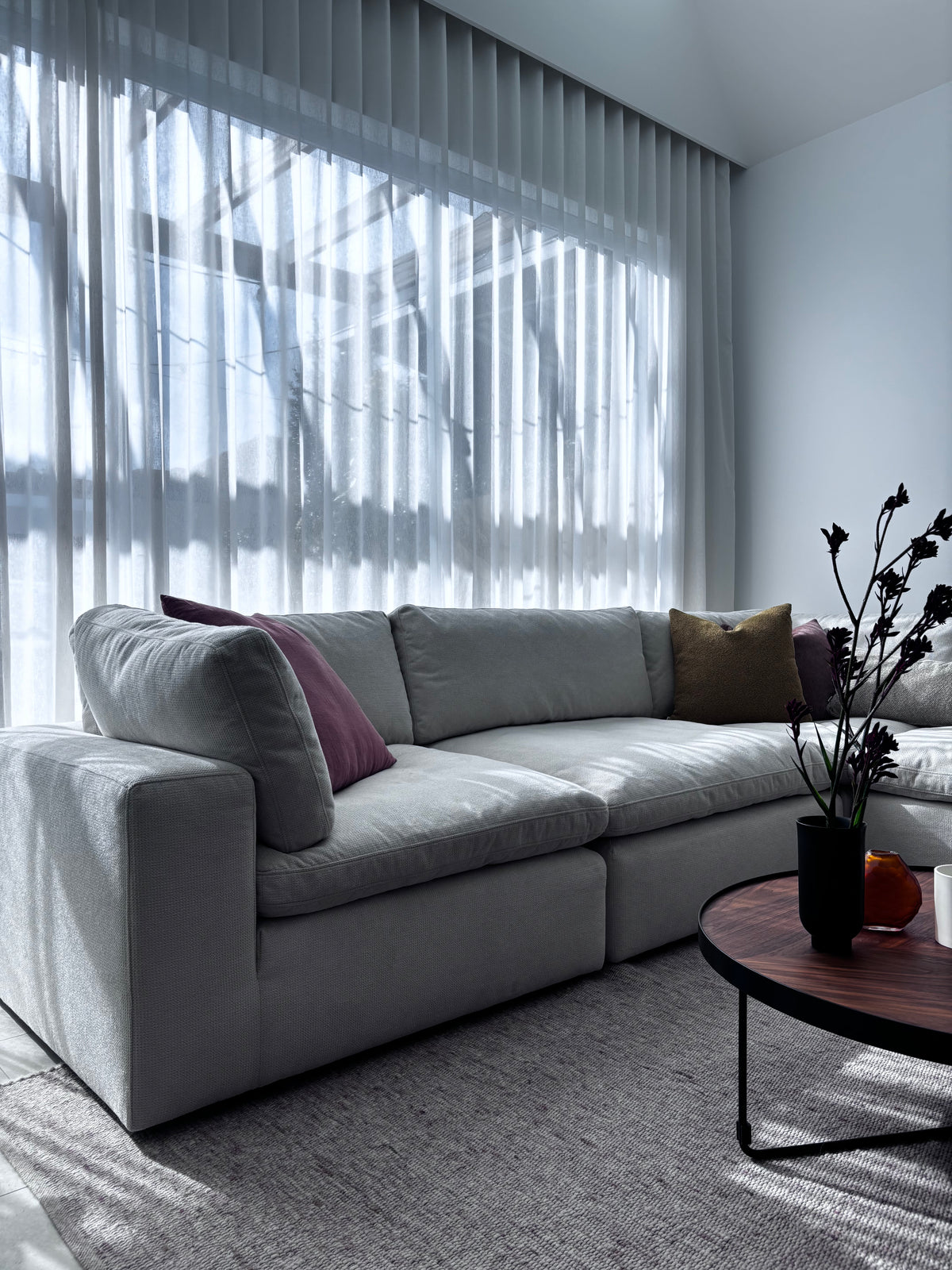 Billie modular lounge styled with a woven rug, side table, and decorative accents