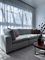 Billie modular lounge styled with a woven rug, side table, and decorative accents
