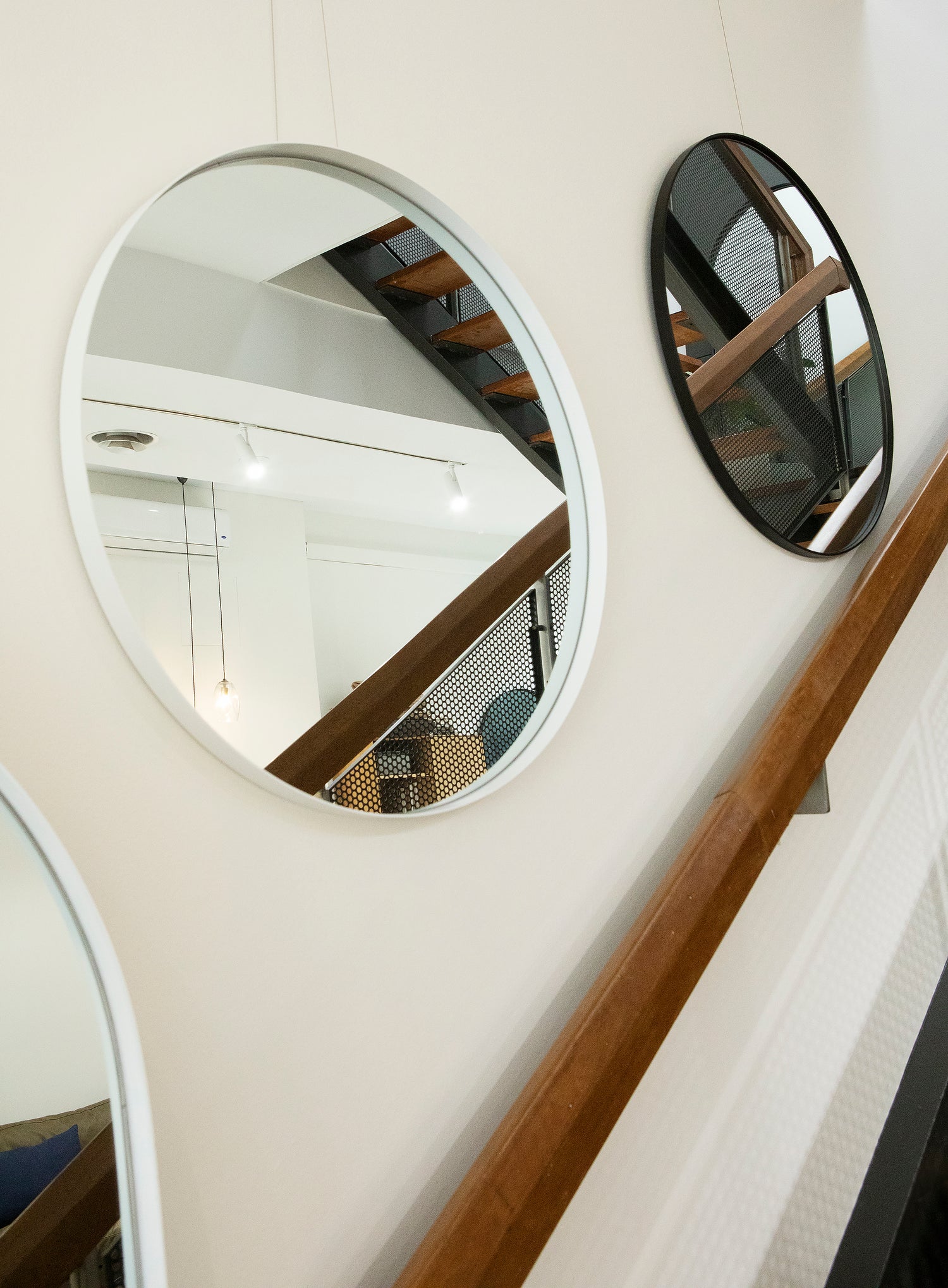 White Bobbi Round Mirror used as a hanging mirror in a styled store environment, adding depth and roundness