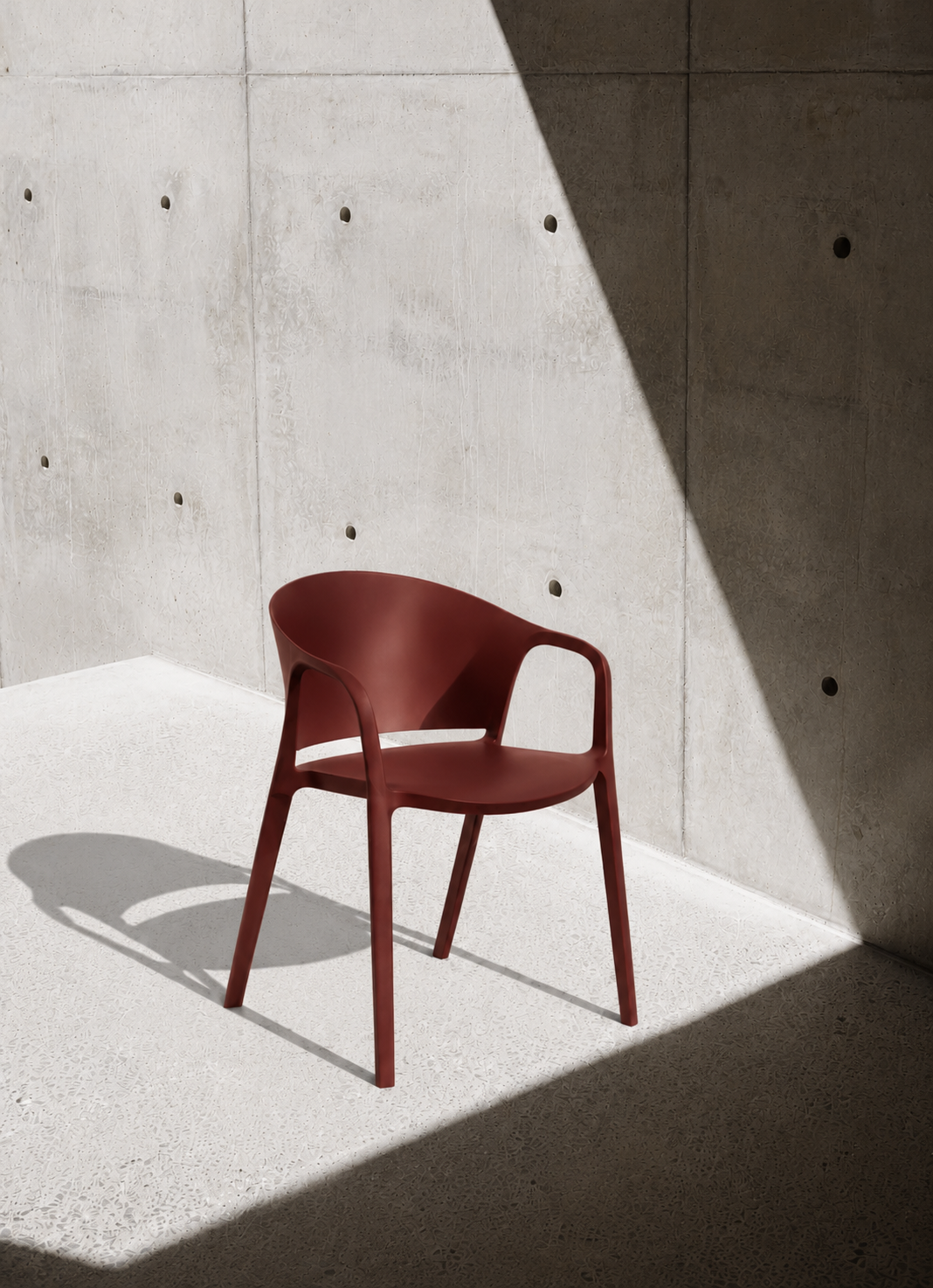 Carla Stacking Armchair photographed against a concrete backdrop