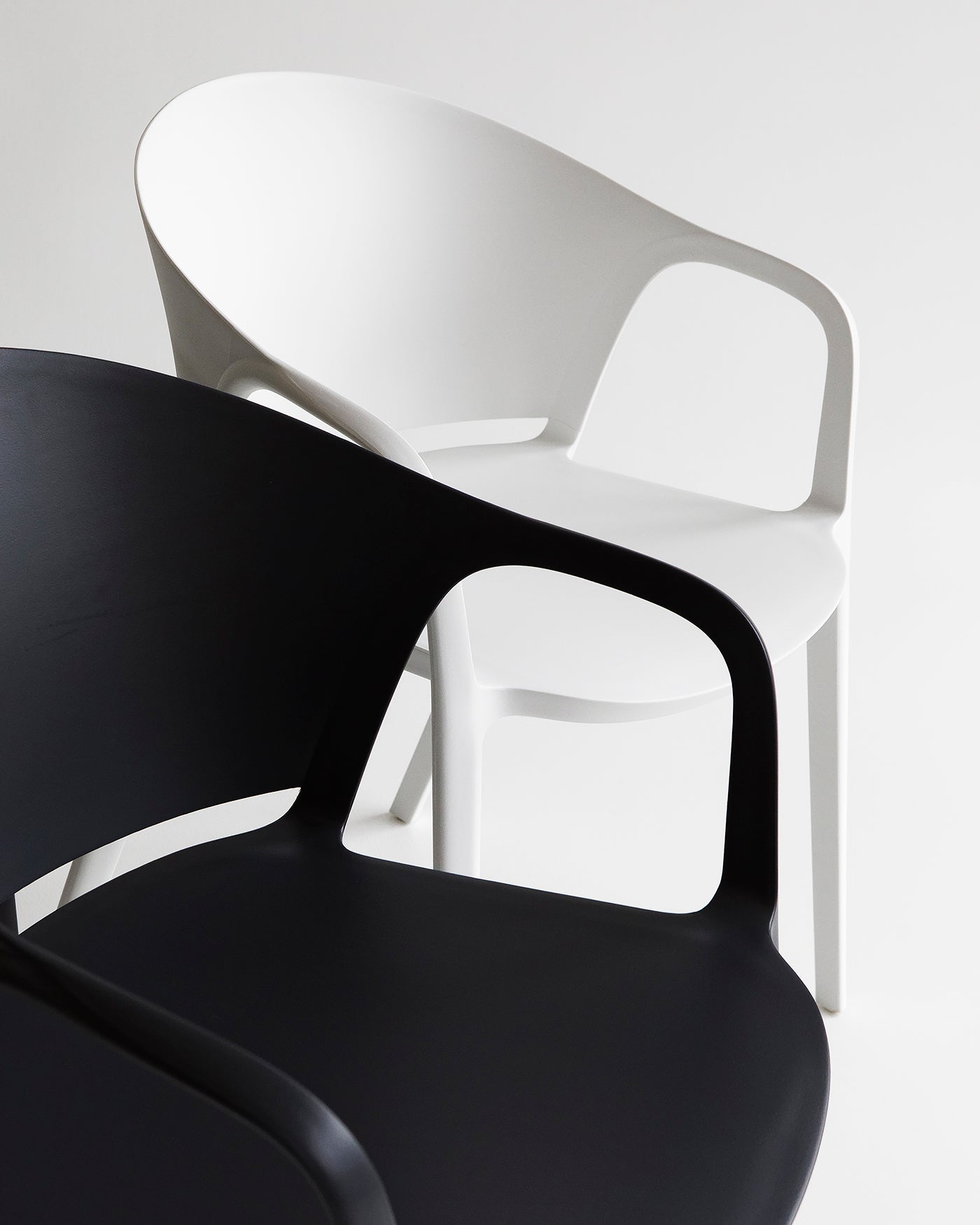 Close-up of the Carla Armchair in Black showing smooth polypropylene finish and ergonomic armrest