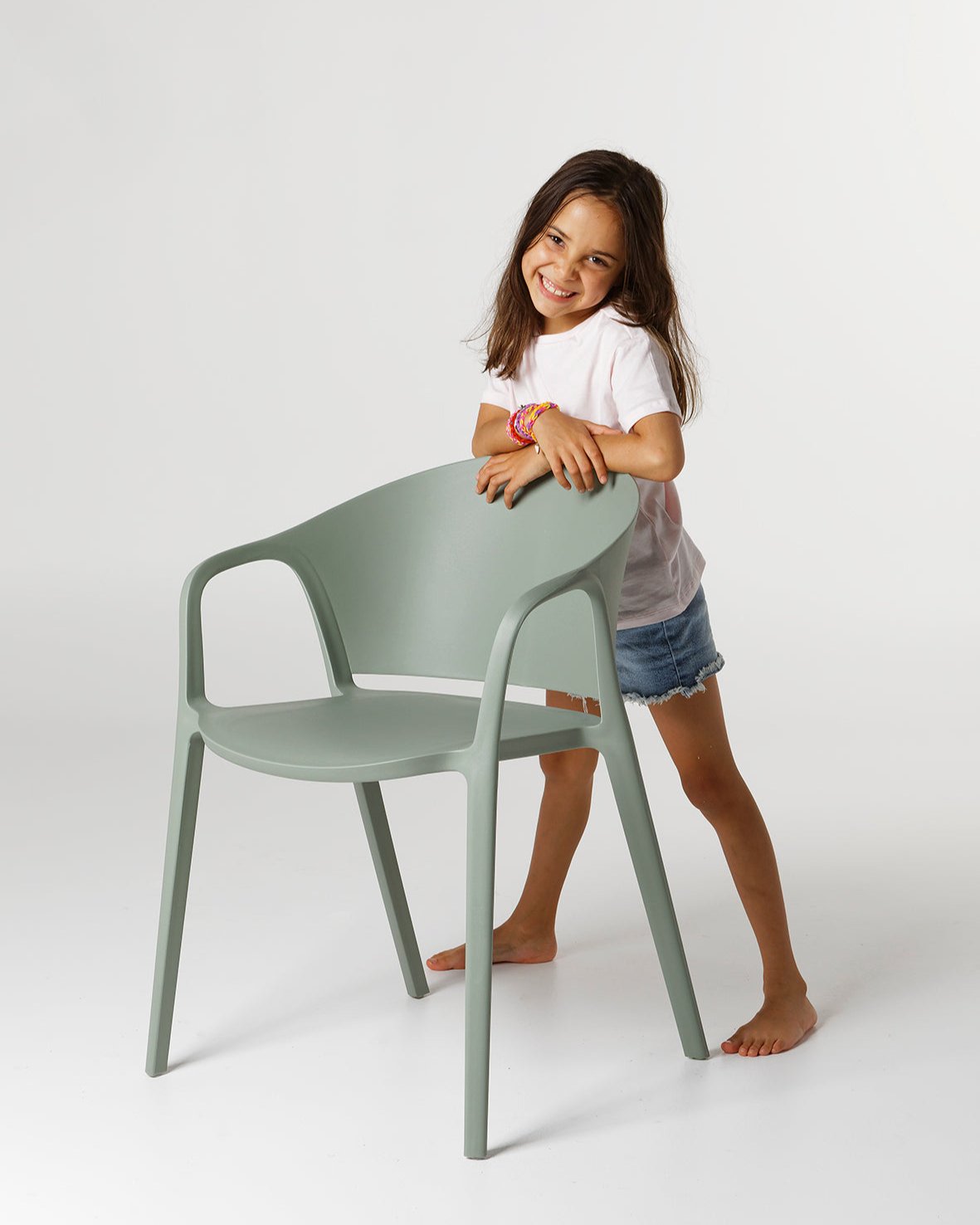Side view of the Sage Carla Armchair showing curved armrests and contoured backrest in durable polypropylene.