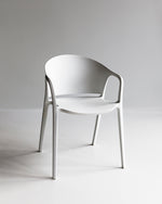 White Carla Chair shown in a minimal studio setting, highlighting its clean lines and bright matte finish.