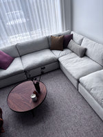 Comfortable sofa arranged with a round coffee table and neutral rug in a living room setting