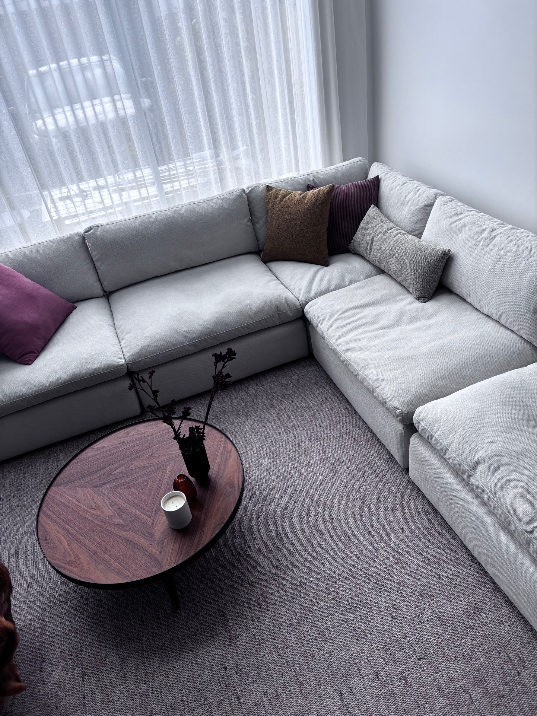 Comfortable sofa arranged with a round coffee table and neutral rug in a living room setting