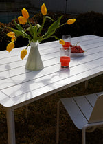 Stylish white outdoor dining table paired with comfortable outdoor seating