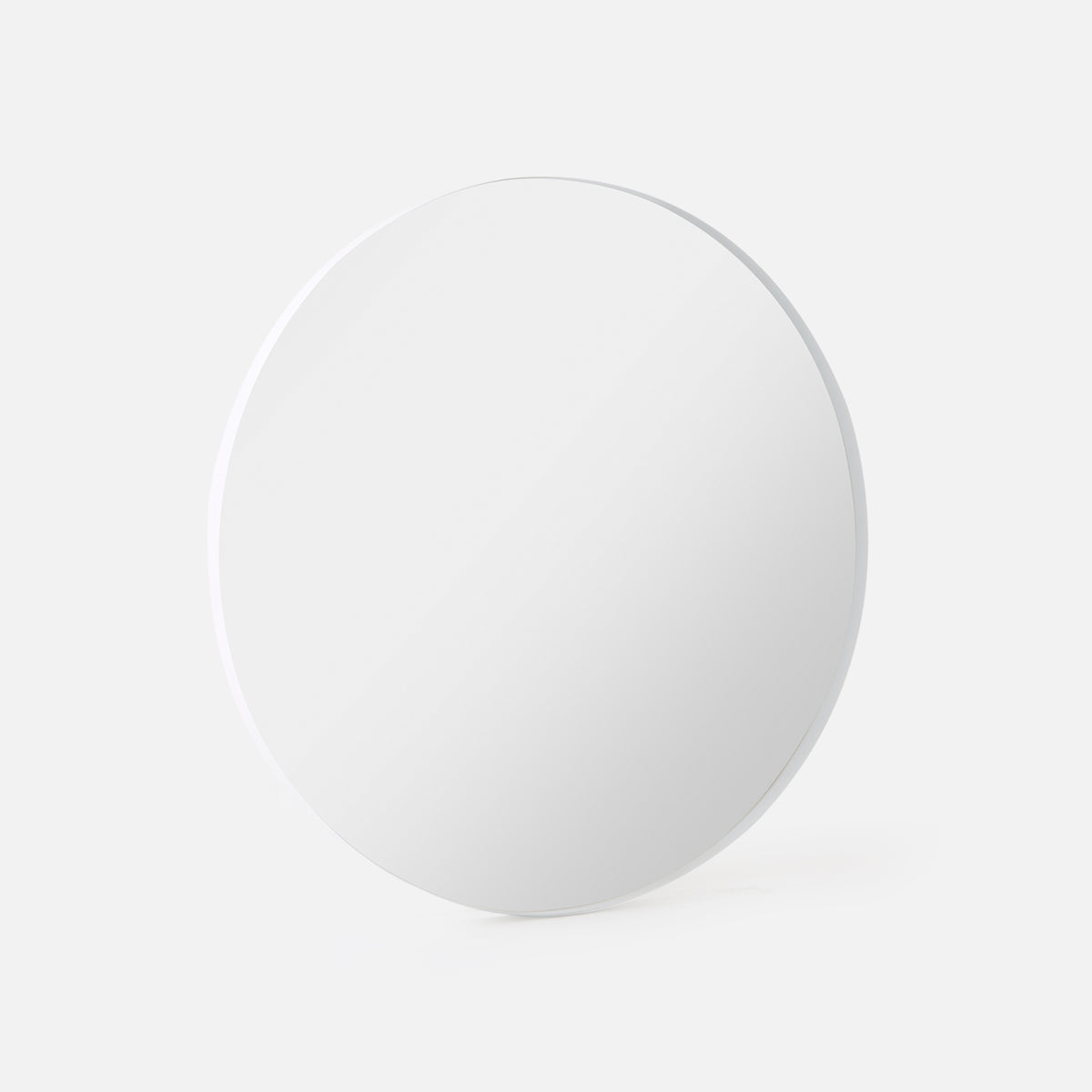 Bobbi Round Mirror in white shown at an angle, showing the depth of its frame