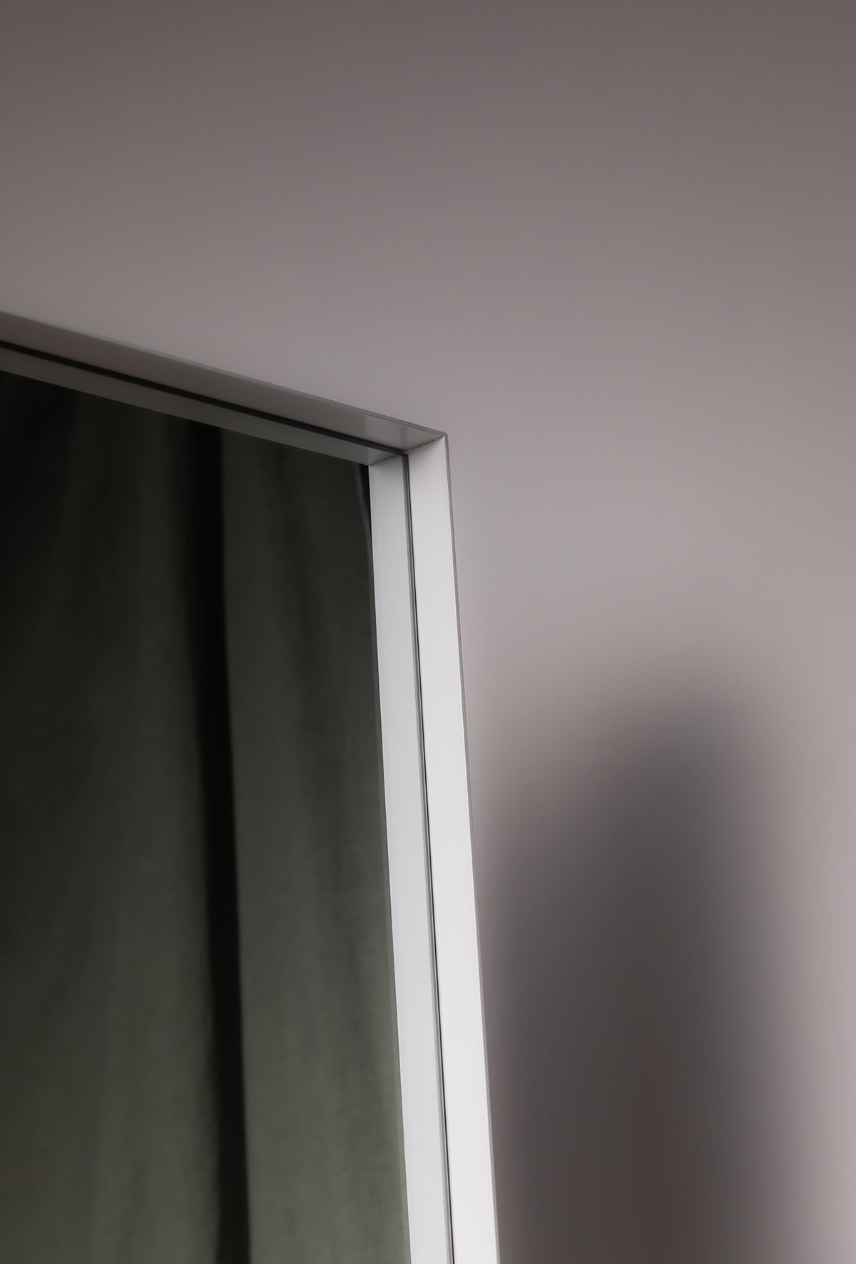 Close-up of the Luca Oversized Mirror in white, showing its slim metal frame