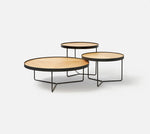 Sia round oak table styled with matching deep etched medium and high tables in architectural setting
