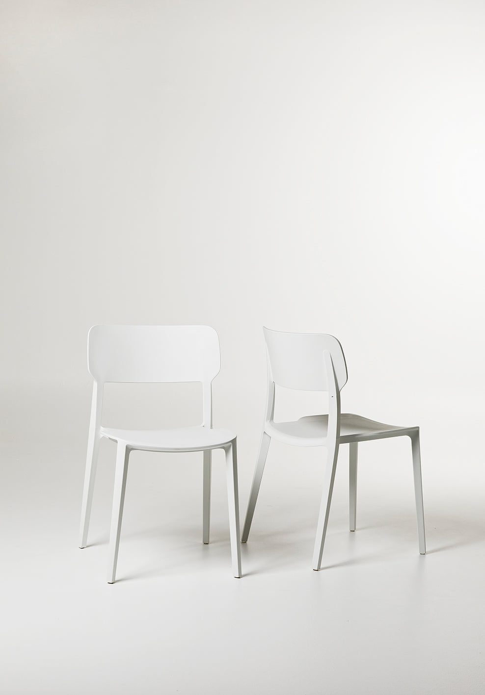 Angled shot of the White Alex Chair showing its lightweight frame and soft matte finish.