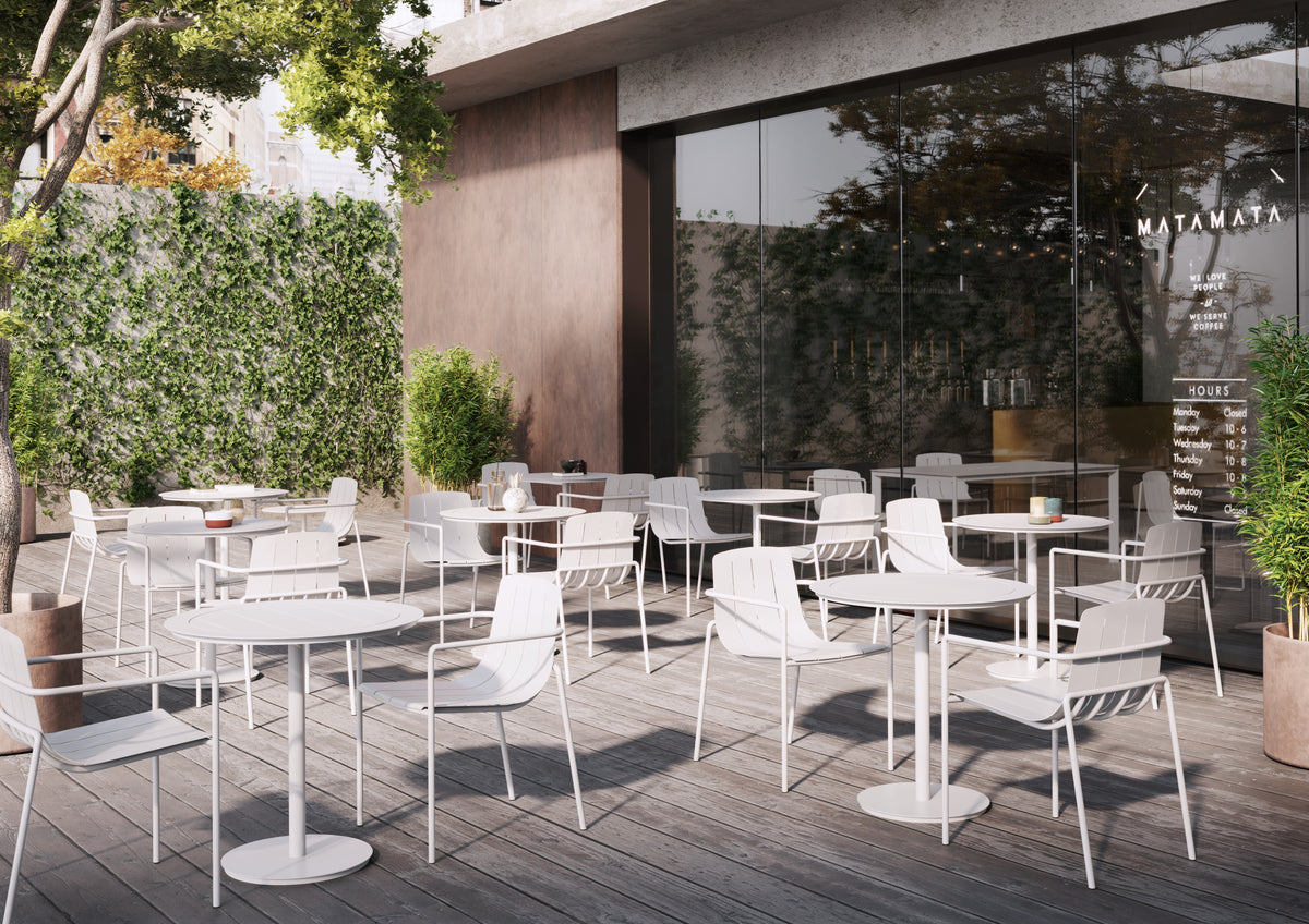 White Remy Outdoor Dining Armchairs paired with small outdoor tables in a commercial setting, ideal for cafés, restaurants, and alfresco dining areas.