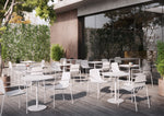 White Remy Outdoor Dining Armchairs paired with small outdoor tables in a commercial setting, ideal for cafés, restaurants, and alfresco dining areas.