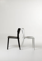 Side view of the Alex Chair in Black and White streamlined silhouette with contoured back and sturdy plastic frame.