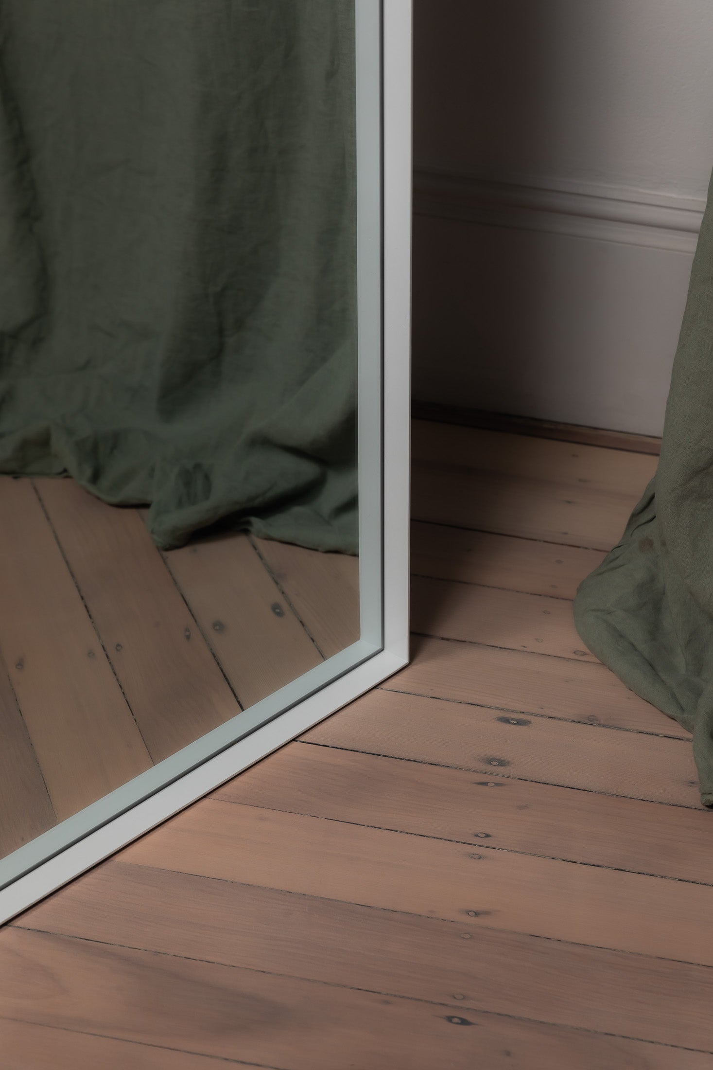 Close-up of the arched top of the white Archie full length mirror