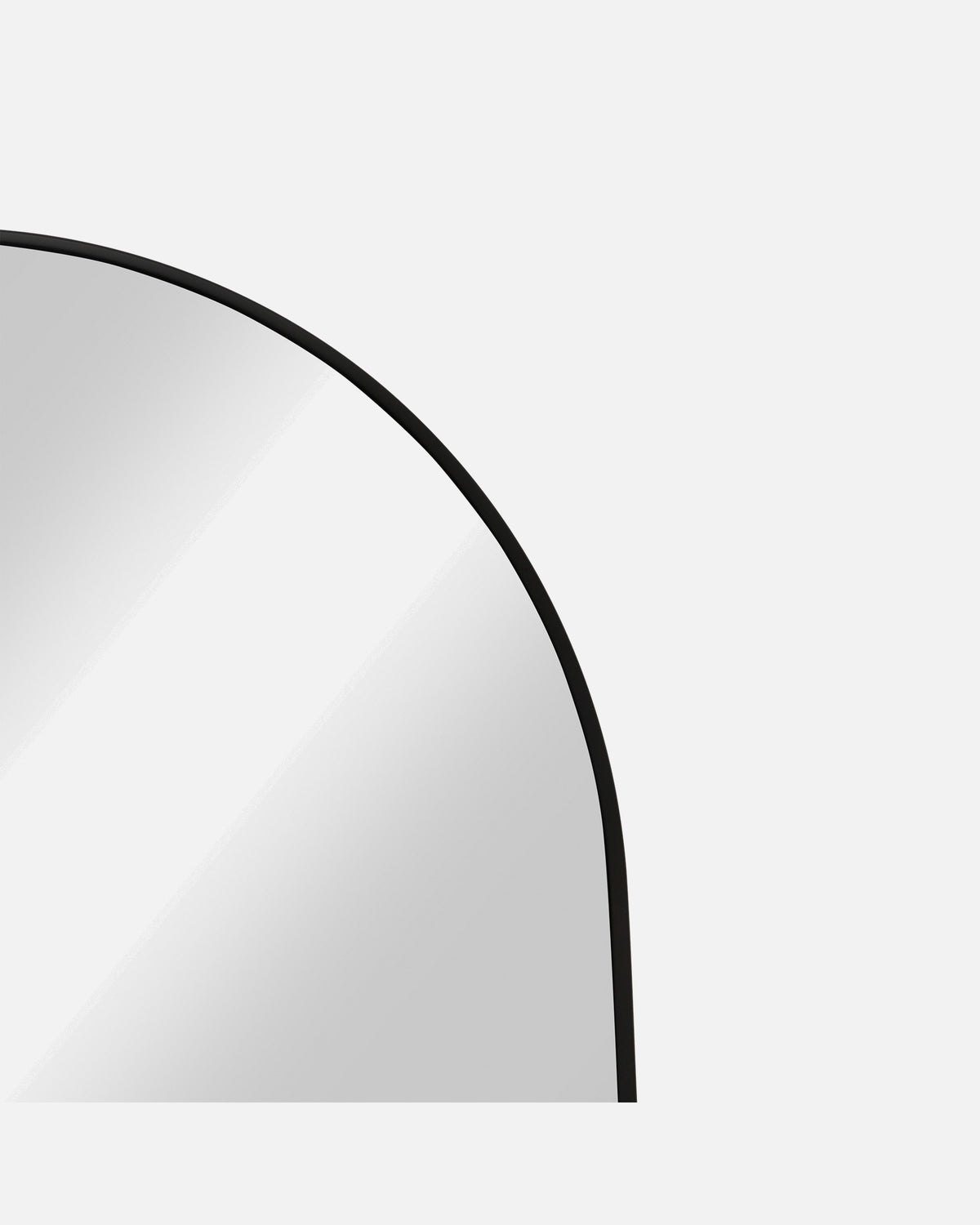 Close-up of the Archie Oversized Mirror's arched corner and slim black metal frame