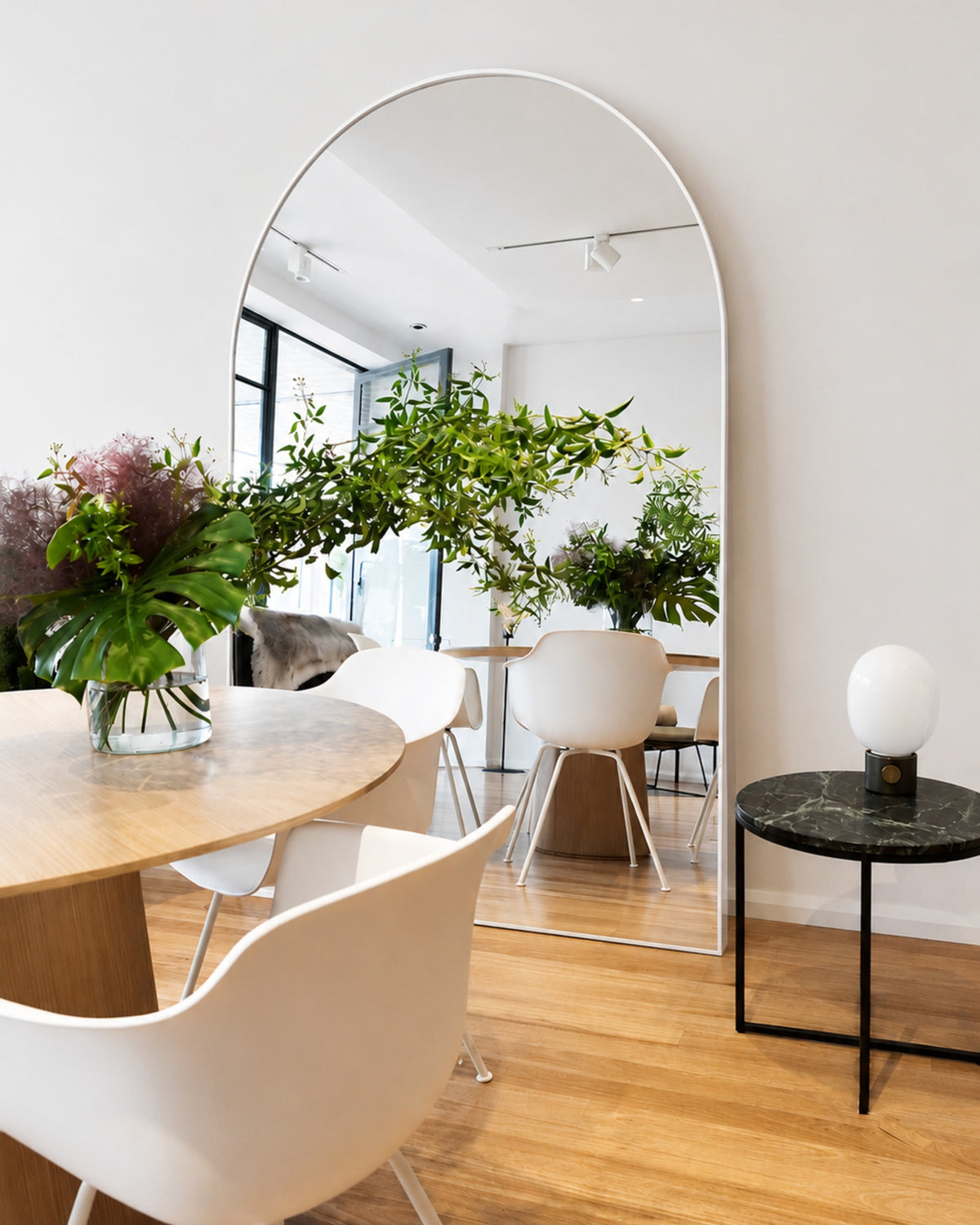 Archie Oversized Mirror in white leaning in a dining room setting