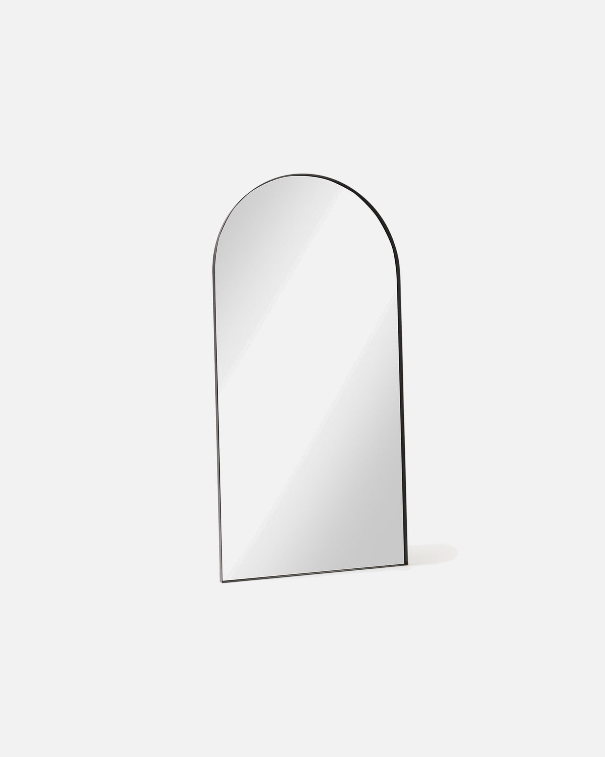 Archie Standard Mirror in black shown at an angle, showing the depth of its metal frame
