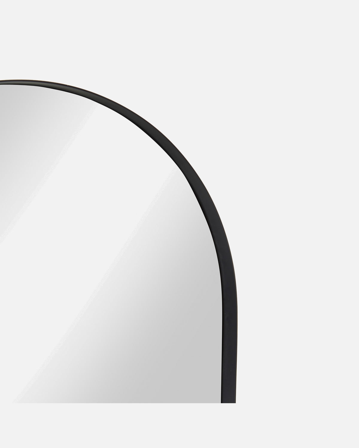 Close-up of the Archie Standard Mirror's arched corner and slim black metal frame