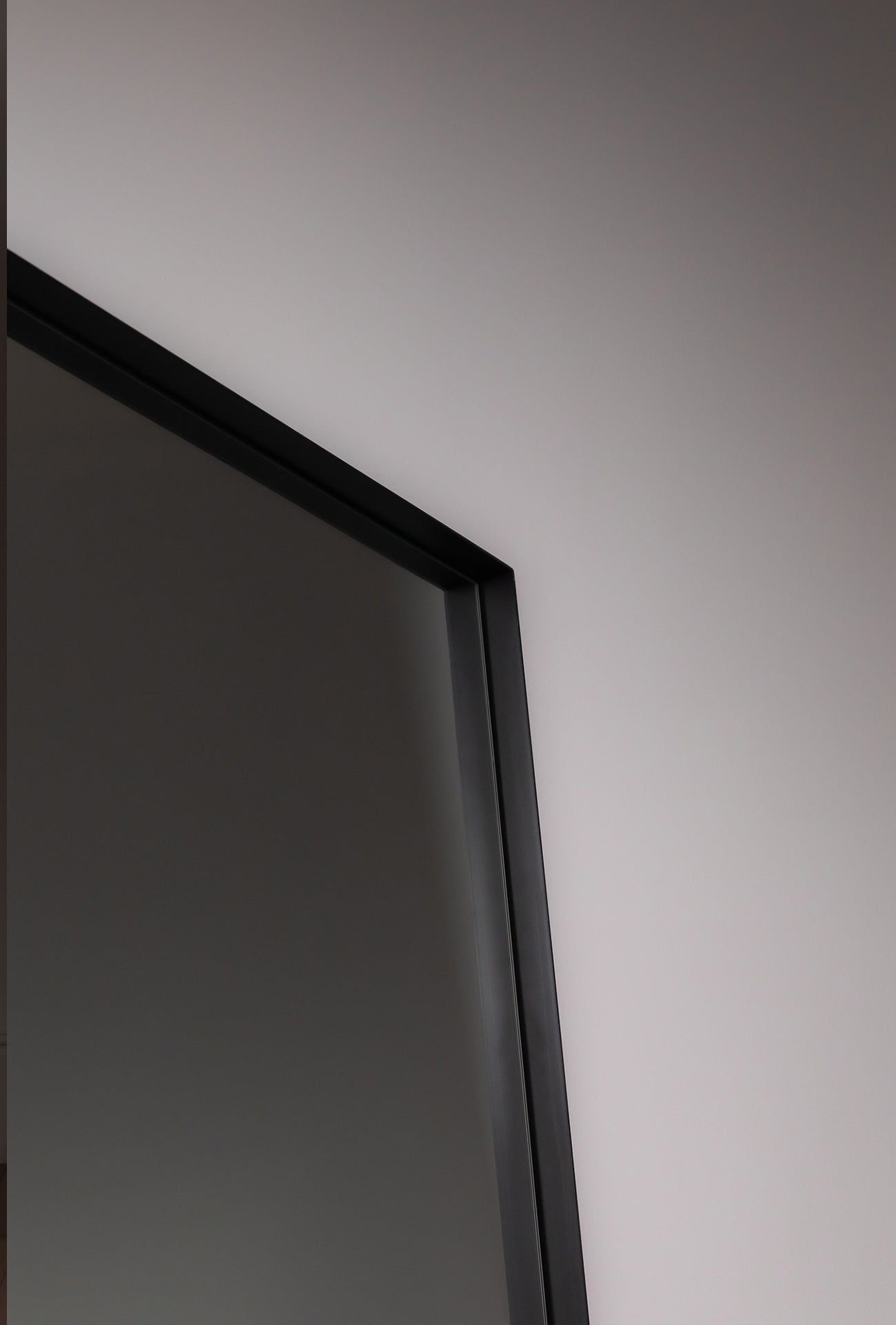 Corner detail of black deep etched Luca Mirror showing clean lines and matte texture
