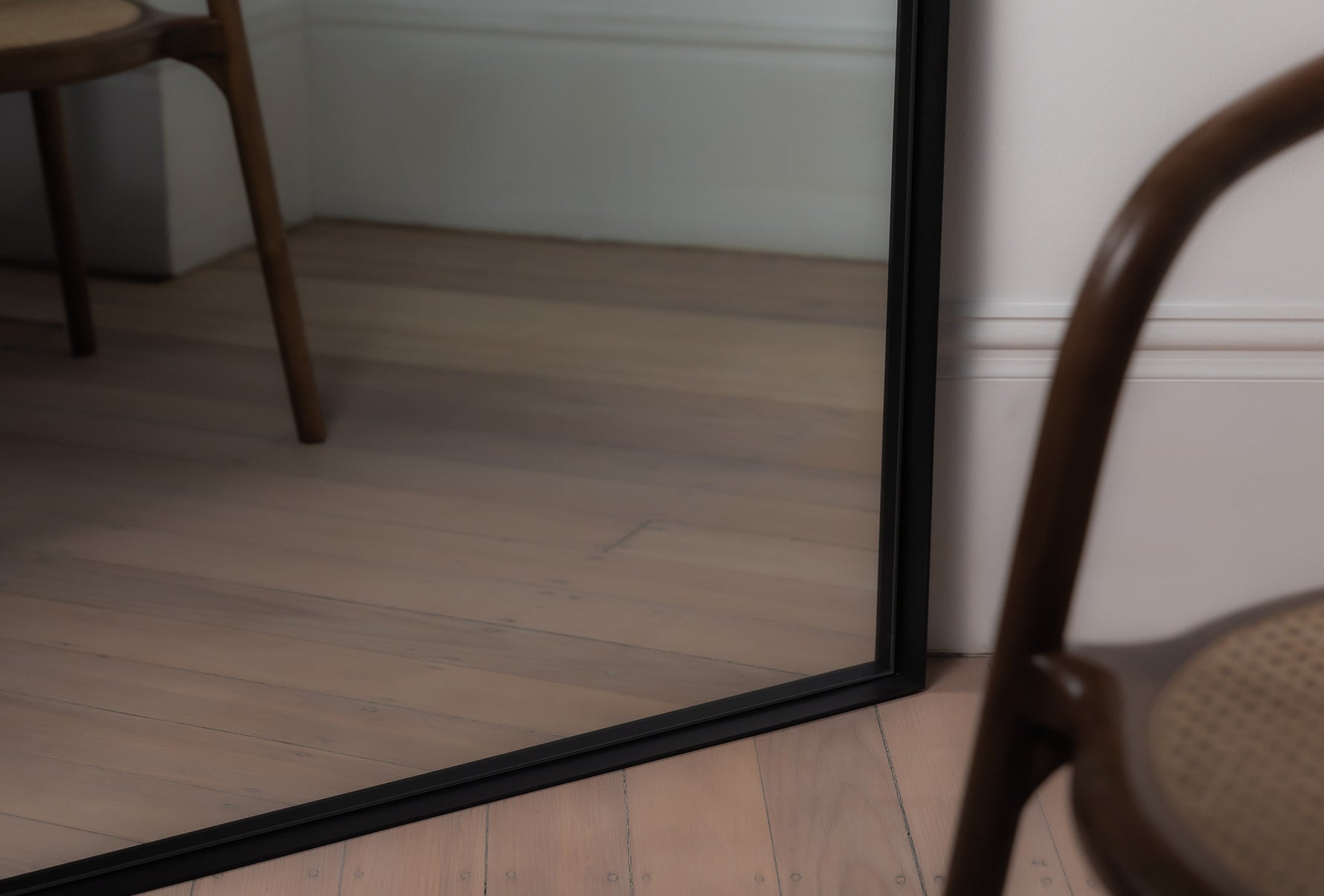 Close-up of the black Luca Mirror corner showing powder-coated finish