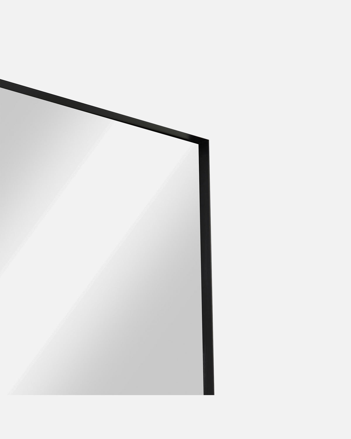 Close-up of the Luca Oversized Mirror's corner and slim black metal frame