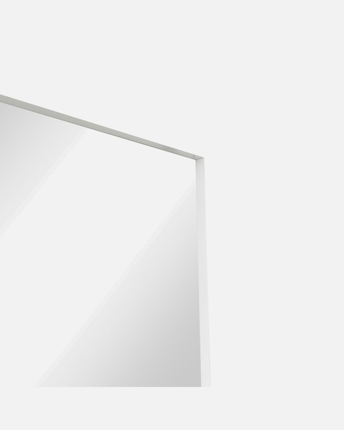 Close-up of the Luca Standard Mirror's corner and slim white metal frame