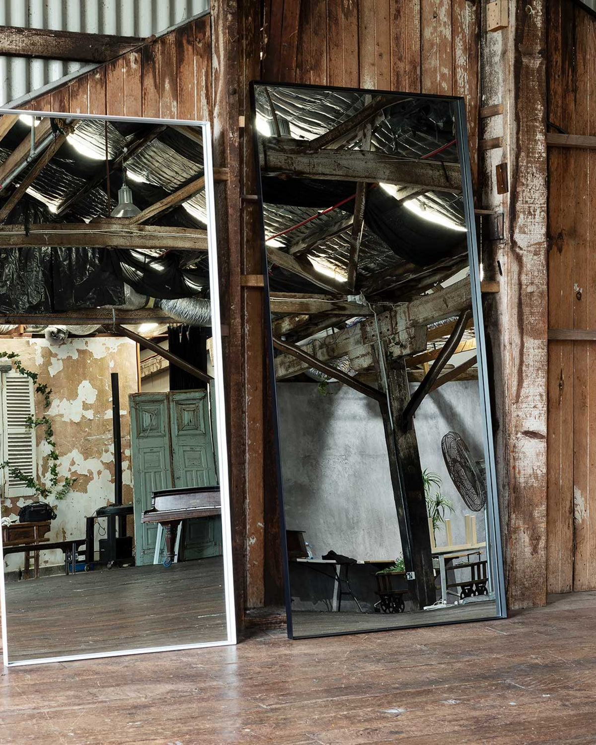 Luca mirrors styled together, the white Standard beside the black Oversized against a timber wall