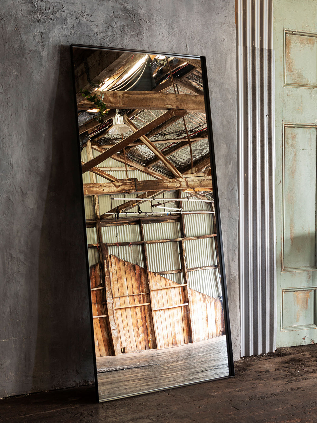 Black Luca full length mirror in open warehouse space with concrete floor